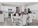 Modern kitchen with stainless steel appliances, white cabinetry, a tile backsplash, and a marble-topped table at 55 S Edge Cliff St, Castle Rock, CO 80104