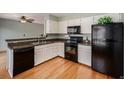 Efficient kitchen featuring white cabinets and black appliances and hardwood floors at 8753 W Cornell Ave # 12-1, Denver, CO 80227