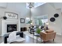 Bright living room with high ceilings, a cozy fireplace, and stylish contemporary furniture at 4858 S Tibet St, Aurora, CO 80015