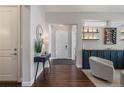Inviting entryway with hardwood floors, console table and wall art, flowing into the open living area at 9724 Cantabria Pt, Lone Tree, CO 80124