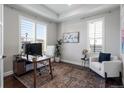 Bright home office featuring white walls, wood floors, modern desk, chair, and stylish decor at 9724 Cantabria Pt, Lone Tree, CO 80124