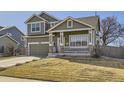 View of charming two-story home featuring a covered porch, stone accents, and well-maintained lawn at 1542 Cherry St, Brighton, CO 80601