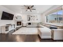 Bright living room with hardwood floors, a fireplace, large sectional sofa, and ample natural light at 16673 E Virginia Ave, Aurora, CO 80017