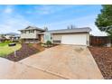 View of the two story home, driveway, and surrounding foliage at 7333 S Dexter Way, Centennial, CO 80122