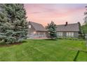 Expansive backyard featuring lush lawn, mature trees, and patio area at 1019 24Th St, Golden, CO 80401