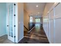 Spacious hallway with wood floors, white wainscoting, and a view into the open floor plan at 4580 S Ukraine Cir, Aurora, CO 80015