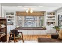 Bright living room features a large window seat with storage, built-in shelves, and hardwood floors at 721 Monroe St, Denver, CO 80206