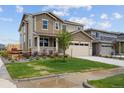 Two-story home featuring a two car garage, front porch and nicely manicured lawn at 24707 E 40Th Ave, Aurora, CO 80019