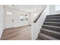 Bright living room featuring gray carpet on stairs, wood floors and front door views at 24707 E 40Th Ave, Aurora, CO 80019