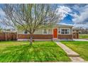 Charming single-story home with a well-maintained lawn, red brick accents, and a vibrant orange front door at 2850 Roosevelt, Thornton, CO 80229