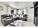Comfortable living room with a large leather sofa, neutral decor, and an inviting, airy feel at 2850 Roosevelt, Thornton, CO 80229