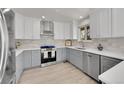 Modern kitchen with stainless steel appliances, gray cabinets and white countertops at 8008 W Spanish Peak, Littleton, CO 80127