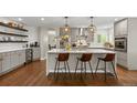 Modern kitchen featuring a large island, pendant lighting, stainless steel appliances, and hardwood floors at 19061 Eagle Ridge Dr, Golden, CO 80401