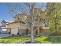Beautiful home with a well-manicured lawn, fountain, and mature tree in the front yard at 10703 Flagler Dr, Parker, CO 80134