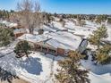 Ranch style home with large backyard, snowy landscape, and mountain views at 6017 Thunder Hill Rd, Parker, CO 80134