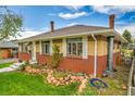 Side view of brick house with manicured lawn, stone border, and chimney at 7861 Osceola St, Westminster, CO 80030