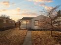 A cozy white house with a small porch and a bare tree in the yard, seen at twilight, adds to its charm at 3245 S Elati St, Englewood, CO 80110