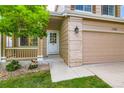 Close up front door and 2 car garage with a well-manicured lawn and front porch at 11363 Latigo Ln, Parker, CO 80138