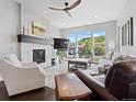 Bright living room with a cozy fireplace, large windows offering scenic views, and stylish modern furnishings at 6268 Dakota Ridge Dr, Littleton, CO 80125