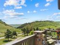 Relaxing patio featuring comfortable armchairs, a small table, and scenic views of rolling hills and blue sky at 6268 Dakota Ridge Dr, Littleton, CO 80125
