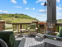 Inviting outdoor patio with comfortable seating and stunning views of the surrounding landscape and hills in the background at 6268 Dakota Ridge Dr, Littleton, CO 80125