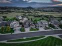 Expansive aerial view of suburban neighborhood at dusk, showcasing manicured lawns and mountain views at 1176 Dales Pony Dr, Castle Rock, CO 80104