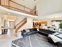 Open-concept living room with a staircase, large sectional sofa, and views to kitchen at 412 E 131St Ave, Thornton, CO 80241