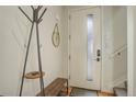 Modern entryway with light walls, a coat rack, a mirror, a bench and a front door with a window at 2138 N Glenarm Pl, Denver, CO 80205