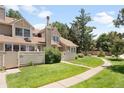 Charming two-story home boasts a lush front yard, manicured landscaping, and a welcoming walkway at 7373 E Iowa Ave # 1124, Denver, CO 80231