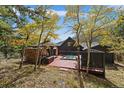 Backyard showcasing a spa and covered patio area surrounded by trees at 239 Aspen Pl, Evergreen, CO 80439