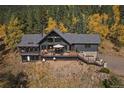 Aerial view of the mountain home showing its extensive deck, large windows, and natural surroundings at 239 Aspen Pl, Evergreen, CO 80439
