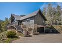 Charming home with stone accents, a well-manicured lawn, and a grand entrance showcasing the property's curb appeal at 239 Aspen Pl, Evergreen, CO 80439