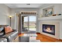 Living room with fireplace, wood floors and sliding door to outdoor patio at 9538 W San Juan Cir # 104, Littleton, CO 80128