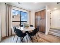 Charming dining area with a round marble table and large window providing natural light at 2036 S Holly St # 1, Denver, CO 80222