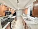 Well-equipped kitchen featuring stainless steel appliances, tile floors and ample counter space at 8590 Faraday St, Denver, CO 80229