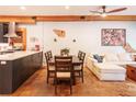 Open concept living room featuring modern decor, wood beams, exposed brick, and a dining table set at 117 Elati St # 1, Denver, CO 80223