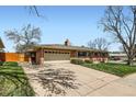 Beautiful home with a brick exterior, lush green lawn, and a two-car garage at 6773 E Baker Pl, Denver, CO 80224