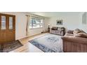 Inviting living room with a large window, wood floors, and comfortable seating at 6773 E Baker Pl, Denver, CO 80224