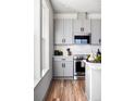 Modern kitchen with gray cabinets, stainless steel appliances, and white countertops at 10876 Lyric St, Lone Tree, CO 80134