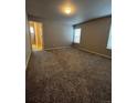 Spacious bedroom with neutral walls, carpet flooring, and natural light from two windows at 899 Winding Brook Dr, Berthoud, CO 80513