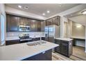 Modern kitchen with stainless steel appliances, dark cabinets, and a central island with a sink at 899 Winding Brook Dr, Berthoud, CO 80513