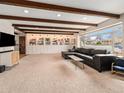 Spacious living room with custom built-in shelving, modern media center, and large picture window at 7105 Dover Way, Arvada, CO 80004