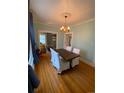 Bright dining room with hardwood floors, modern chandelier, and a view into the living room at 422 E 6Th Ave, Denver, CO 80203