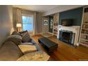 Inviting living room featuring hardwood floors, a cozy fireplace, and natural light from a large window at 422 E 6Th Ave, Denver, CO 80203