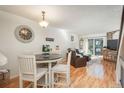 Open floor plan with hardwood floors; dining room view showcases living area and sliding door to back patio at 3506 S Depew St # 3, Denver, CO 80235