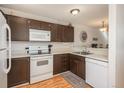 Efficient kitchen design with white appliances, wood cabinets, and practical layout for easy meal preparation at 3506 S Depew St # 3, Denver, CO 80235