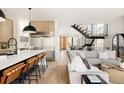 Open-concept living room featuring wood floors, modern staircase, and seamless connection to the gourmet kitchen at 732 S Gaylord St, Denver, CO 80209