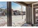 View from covered porch shows a snow-covered street and houses at 6727 Canosa St, Denver, CO 80221