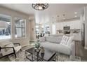 Open concept living room features a gray couch and kitchen with island at 6727 Canosa St, Denver, CO 80221