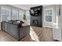 Cozy living room features a fireplace, large windows and hardwood floors at 221 Felicity Loop, Castle Rock, CO 80109